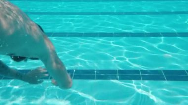 Yüzme havuzu ve su altında kamera. Maskeli bir adam su altında yüzüyor. Yavaş çekim