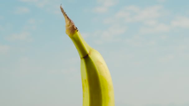 Половина Банана Съемная Часть Вращающаяся Фоне Голубого Неба Крупным Планом — стоковое видео