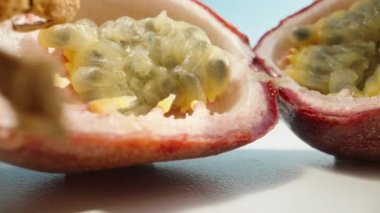 Güneşin altında beyaz bir masada dilimlenmiş tutku meyvesi. Dolly kaydırıcı aşırı yakın çekim.