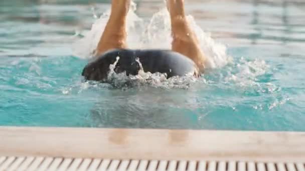 一个戴着粉色泳镜的男子潜入水底 双腿从水里伸向池边 从水底走了出来 慢动作 夏天和外面的阳光 — 图库视频影像