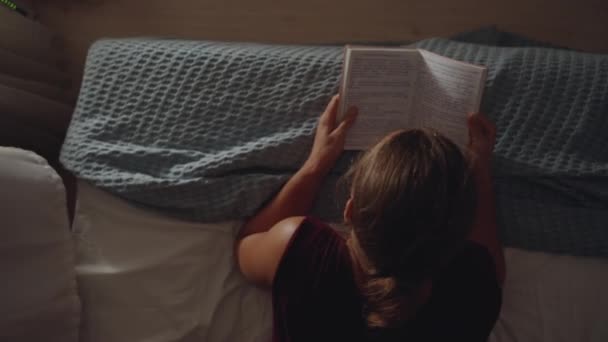 年轻的女人躺在床沿上 看着笔记本 俯瞰四周 — 图库视频影像
