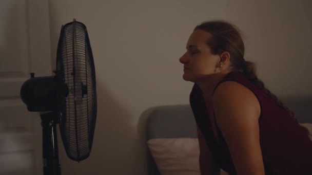 Nocy Młoda Kobieta Siedzi Łóżku Naprzeciwko Wentylatora Jej Włosy Puchną — Wideo stockowe