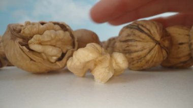 Kabuklu cevizler, onları masadan topluyorum. Mavi gökyüzü, makro