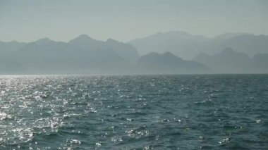 Güneşli bir günde deniz, uzaktaki dağlar, suda hafif bir sis..