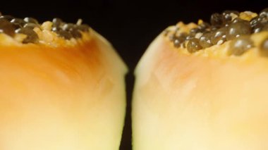Papaya 'yı siyah arka planda iki parçaya ayır. Dolly kaydırıcı aşırı yakın çekim.