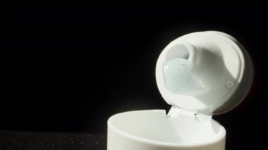 İçinde beyaz diş macunu ve mavi kristaller olan açık bir tüp. Dolly kaydırıcı aşırı yakın çekim.