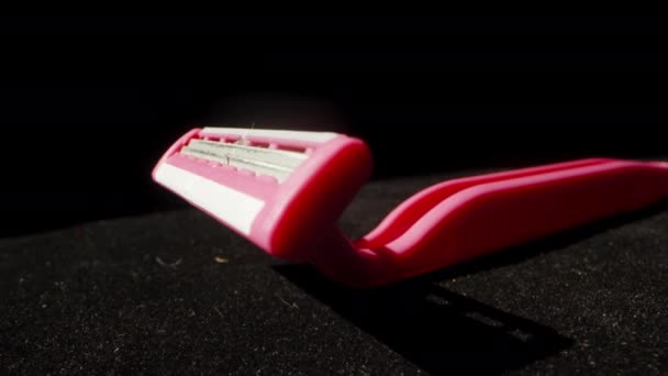 Pinkfarbenes Einweg Rasiermesser Und Klebte Haare Auf Schwarzem Hintergrund Dolly — Stockvideo