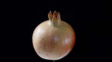 Nar meyvesi siyah bir arkaplanda döner.