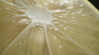 Siyah bir arka planda bir dilim limon tutuyorum, çok yakından çekiyorum..