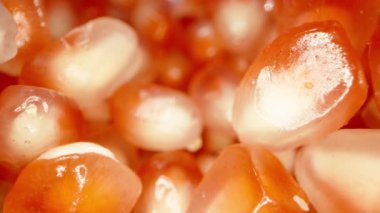 Kamera düşmekte olan kırmızı nar tohumları arasında kayıyor, makro kaydırak.