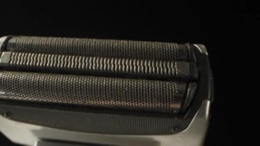 Elektrikli jiletin bir parçasını traş etmek, yakın çekimde döndürmek.