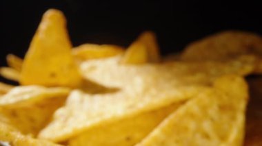 Siyah arka planda bir cips serpintisi, bir tane alıyorum, yakın plan..