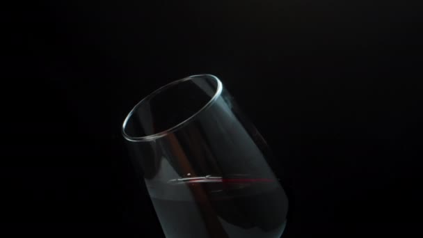 私はガラスの中で赤ワインを振ると 嗅ぎます クローズアップ 黒を背景に スローモーション — ストック動画