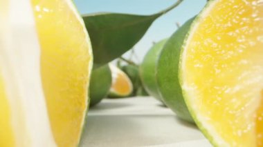 Yeşil kabuklu sulu olgun mandalinalar. Kamera onların arasından geçer. Dolly kaydırıcı aşırı yakın çekim.