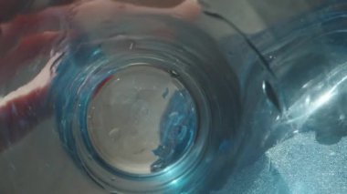 Musluklu bir şişeden bardağa su dolduruyorum. kaydırıcı aşırı yakın çekim.