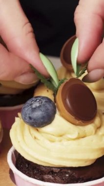 Çikolatalı keklerin dekorasyonuna yer fıstığı kremalı naneyi de ekle. Dikey videoyu kapat.