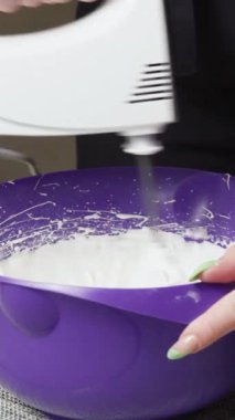 Kremalı pasta yapmak için yumurta beyazlarını mikserle çırpın. Dikey videoyu kapat.