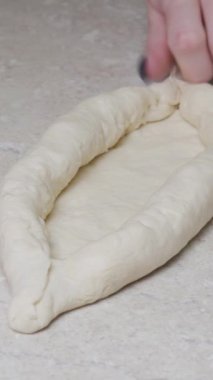 Genç bayan geleneksel Khachapuri 'yi yumurtalı hazırlıyor. Hamur ve peynir, fırına dikey video koyun..