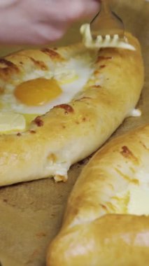 Genç bayan geleneksel Khachapuri 'yi yumurtalı hazırlıyor. Hamur ve peynir, fırına dikey video koyun..