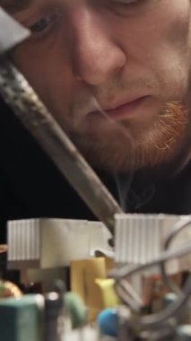 Usta elektrikli aletleri, lehimleri tamir ediyor. Dikey video kaydır.