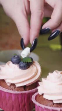Pasta şefi kremalı kekin üzerine küçük bir parça marshmallow koyar..