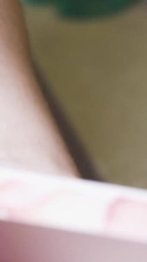 Pasta şefi genç bir kadın hediye kutusunda kek gösteriyor. Dikey video.