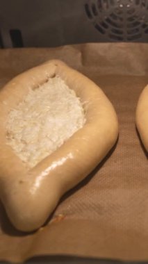 Zaman turları, fırında iki khachapuri pişiyor. Dikey video.