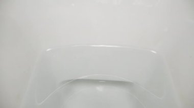 Kağıt tuvalete düşer ve suyla yıkanır. Dolly kaydırıcı aşırı yakın çekim.