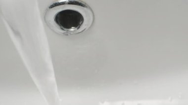 Musluktan lavaboya su akar. Dolly kaydırıcı aşırı yakın çekim.