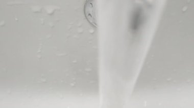 Kamera musluk suyu akıntısından geçer. Dolly kaydırıcı aşırı yakın çekim.