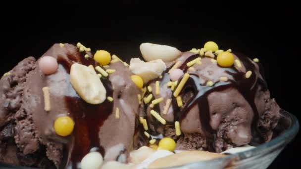 Sklenice Čokoládovými Zmrzlinovými Koulemi Cukrem Otáčí Černém Pozadí Zblízka — Stock video