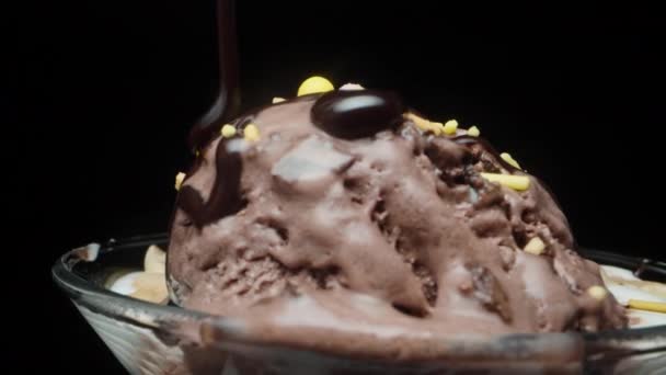 チョコレートアイスクリームと砂糖のスプリンクルのボールが回転し 私はチョコレートでそれらを注ぐ クローズアップ — ストック動画