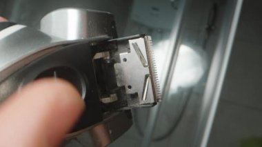 Kızıl sakallı bir adam elektrikli jiletle tıraş olur. Çok geniş bir çerçeve. Kıllar her yöne uçuyor.