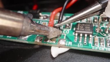 Maşayla tutup siyah kabloyu tahtaya yapıştırmak. aşırı yakın çekim