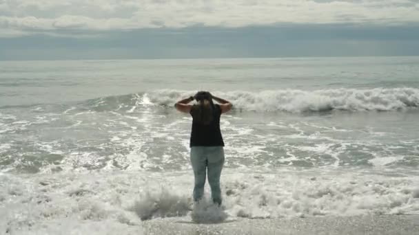 Толстая Молодая Женщина Стоит Море Указывает Приближающиеся Грозовые Облака Волны — стоковое видео
