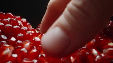 Kamera nar tohumlarının üzerine doğru kayıyor, tohumları alıyorum ve elimden döküyorum. Dolly kaydırıcı, aşırı yakın çekim..