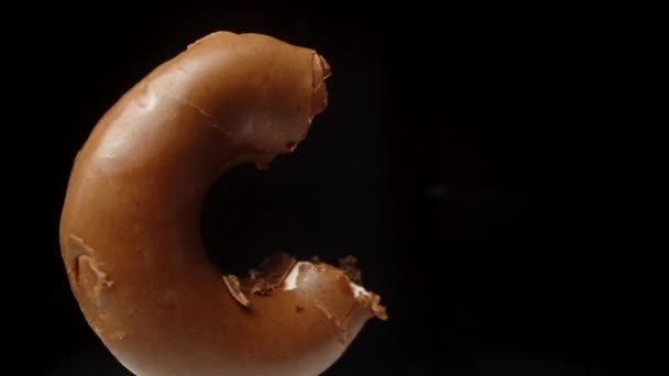 Câmera Passa Por Donut Mordido Que Está Girando Fundo Preto — Vídeo de Stock