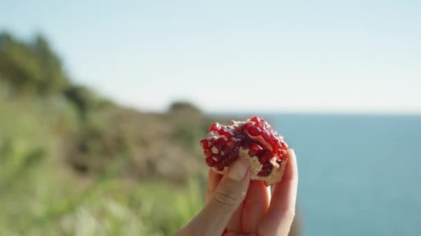 Young Woman Examines Piece Pomegranate Background Sea Close — Stock Video
