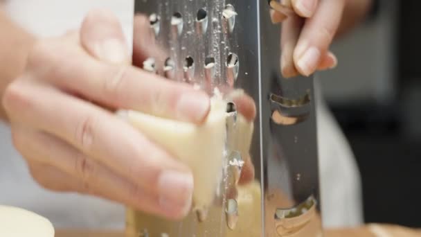 Mädchen Reibt Käse Auf Einer Metallreibe Nahaufnahme Bewegung Zeitlupe — Stockvideo