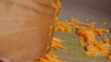 Tahta bir spatulayla karıştır, kızartma tavasında kızartılmış havuçlar, makro shot, POV. Kamera buğulanıyor..