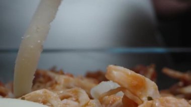 Aşçı lazanyanın üstüne rendelenmiş peynir serpti. Dolly kaydırıcı aşırı yakın çekim.