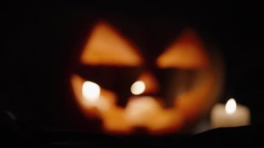 Cadılar Bayramı için balkabağım, mumlar içeride yanıyor. Kameranın odağı yavaşça ona odaklanmış durumda.