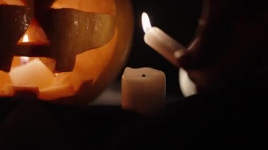 Cadılar Bayramı balkabakları, bir mum yakarım, yakın plan. Gece.