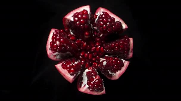 Ett Sönderrivet Granatäpple Roterar Svart Bakgrund Röda Korn Ovanifrån — Stockvideo