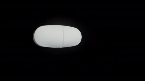 Une Grande Pilule Blanche Tourne Sur Fond Noir Plan Rapproché — Video
