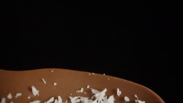 Čokoládová Lžička Ozdobu Černém Pozadí Kokosové Hobliny Něj Padají Dolly — Stock video