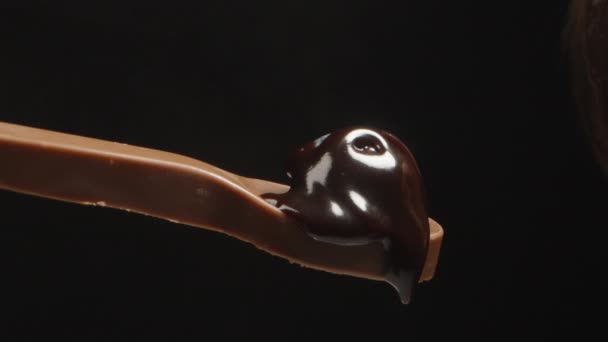 Ein Mann Mit Bart Beißt Einen Schokoladenlöffel Mit Einer Blaubeere — Stockvideo