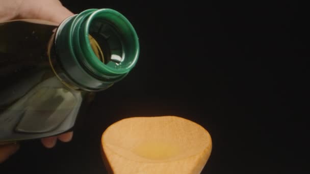 Versare Olio Oliva Una Bottiglia Cucchiaio Legno Sfondo Nero Rallentatore — Video Stock