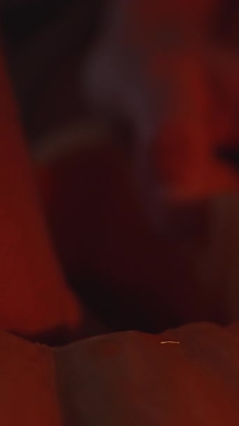 バーティカルビデオ 赤い光で夜にハロウィーンのカボチャを彫った若い女性 インサイドをスカウト クローズアップ — ストック動画