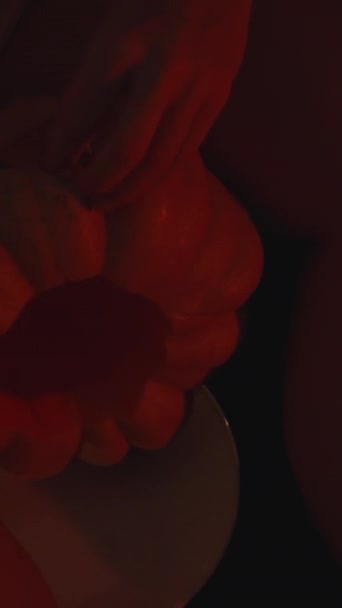 Вертикальне Відео Молода Жінка Темряві Освітлена Свічками Вирізає Очі Гарбуза — стокове відео